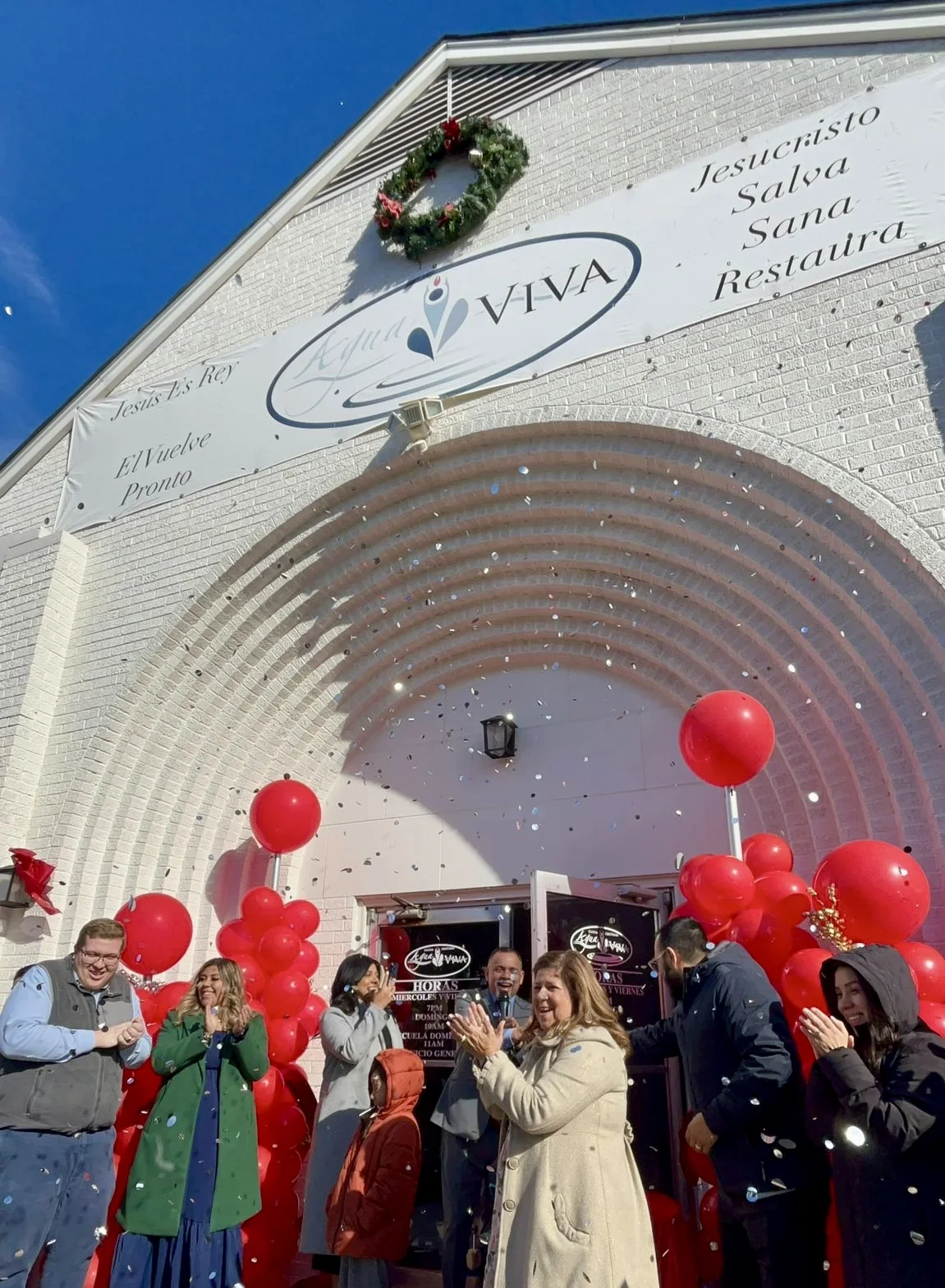 Familia de Agua Viva celebrando frente a la entrada de la iglesia